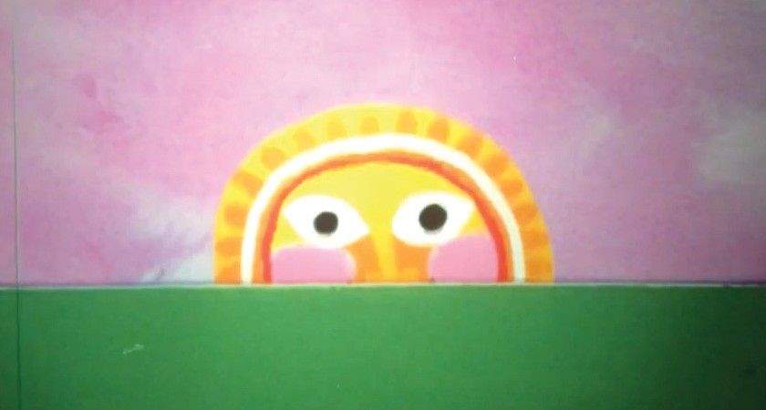 Project of a sun figure with eyes shown peeking over a green strip with a purple background