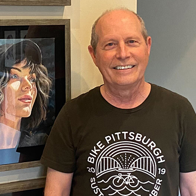 A smiling white man with short gray hair wearing a black Bike Pittsburgh T-shirt