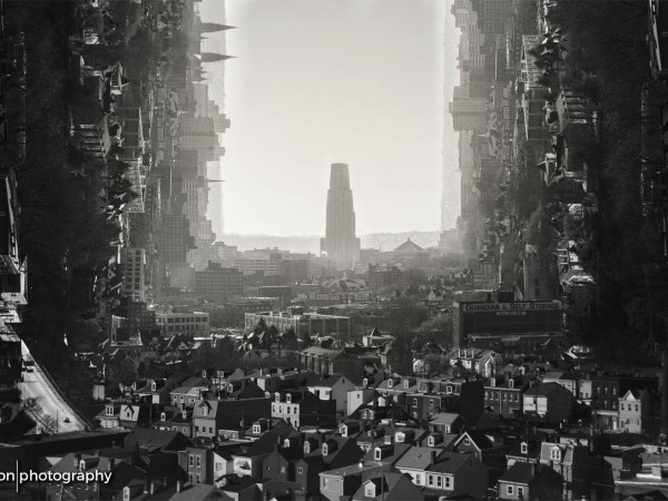 A black-and-white photomanipulation of Oakland. The Cathedral of Learning stands in a pillar of light, and on either side, the streets and building shift from horizontal to vertical in a dream-like bend.