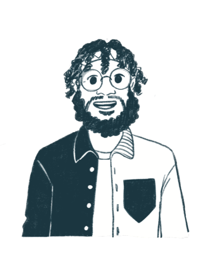 Smiling Black man with blonde hair pulled back with a blue bandana and a dark beard, wearing glasses, a white t-shirt, and a blue, gray, and orange long-sleeved collared shirt