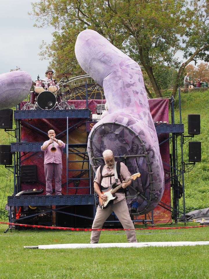 Musicians perform in front of gigantic sculptures of human hands