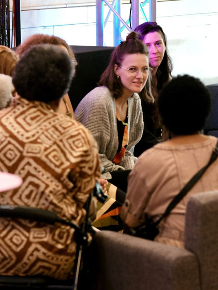 A group of people sit in a circle, engaged in conversation