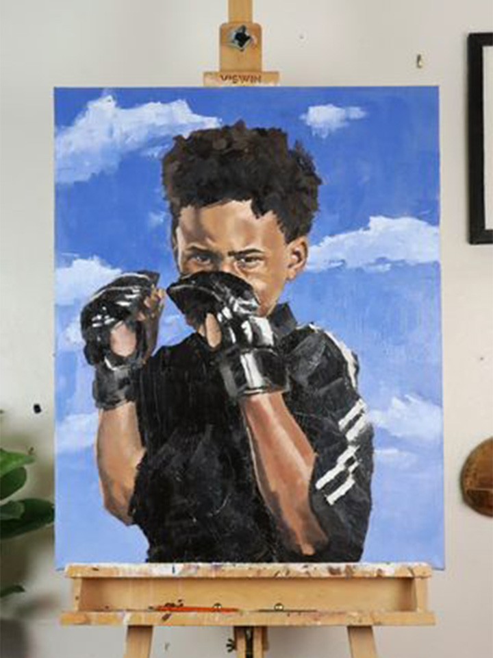An oil painting of a Black boy holding boxing gloves in front of his face