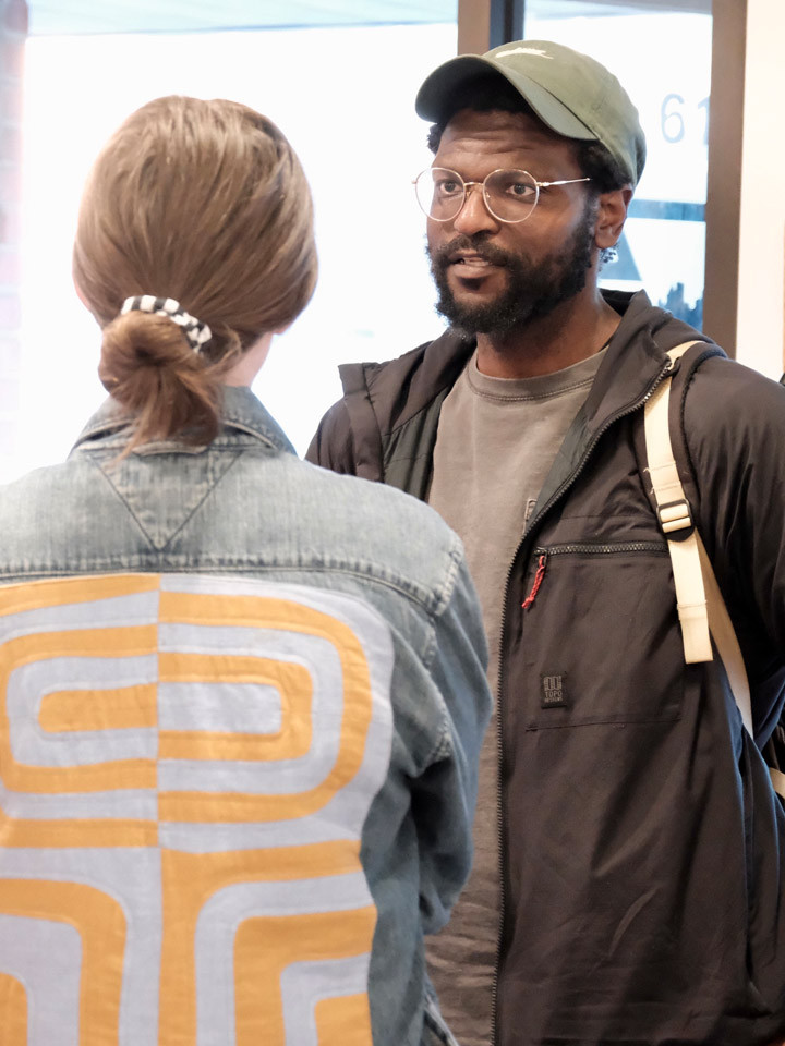 Two people talk inside an arts space