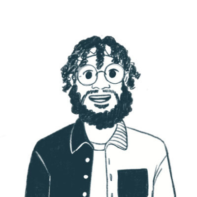 Smiling Black man with blonde hair pulled back with a blue bandana and a dark beard, wearing glasses, a white t-shirt, and a blue, gray, and orange long-sleeved collared shirt