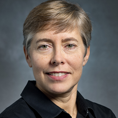 Smiling portrait of woman with short hair wearing a black collared shirt