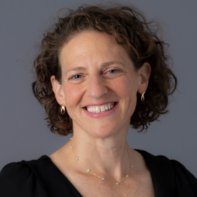 Smiling woman with short curly brown hair wearing black shirt