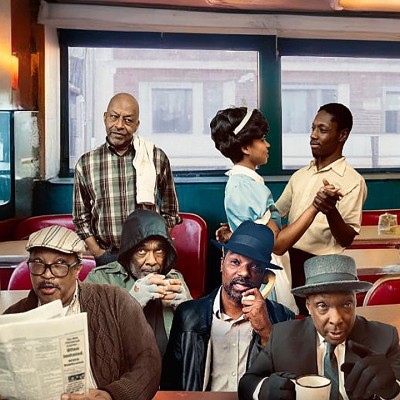 Six Black men sit and stand inside a retro diner. Three sit in front, one reading a newspaper, one sipping coffee, and one in a hat. Behind them, a waitress serves and a couple dances near the counter. The setting is warm and nostalgic.