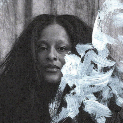 Person with long hair sits behind sheer paint strokes on a textured background.
