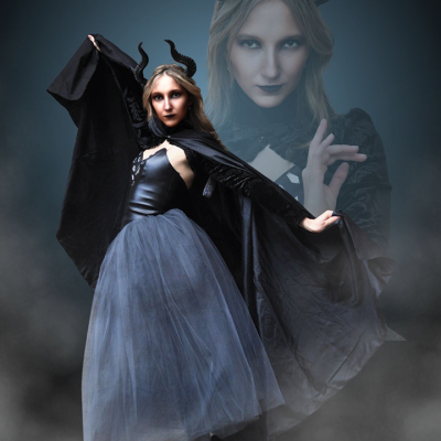Dramatic photo showing a woman dressed up with dark horns, a dress, and a cape