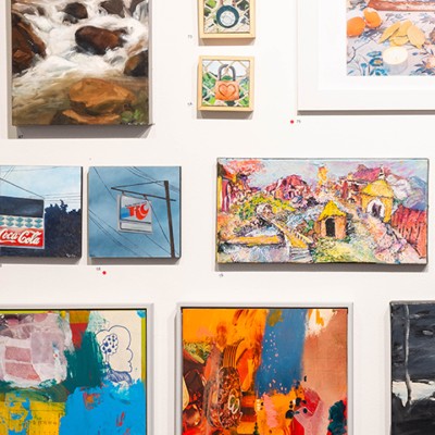 An assortment of colorful artwork of various sizes shown on a white gallery wall