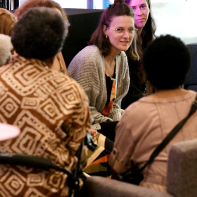A group of people sit in a circle, engaged in conversation