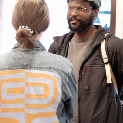 Two people talk inside an arts space