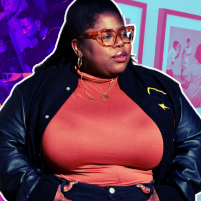 A woman in glasses and a jacket stands confidently against a vibrant background.