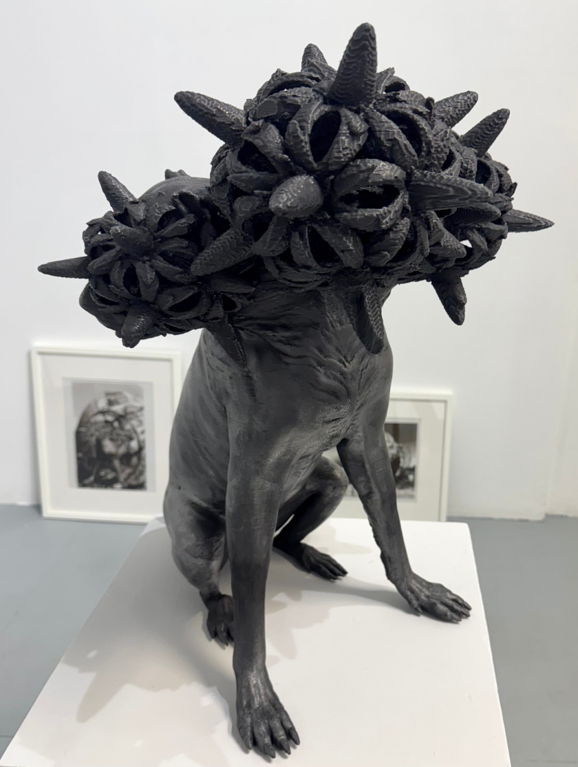 A black dog sculpture with a spiky, abstract form covering its head.