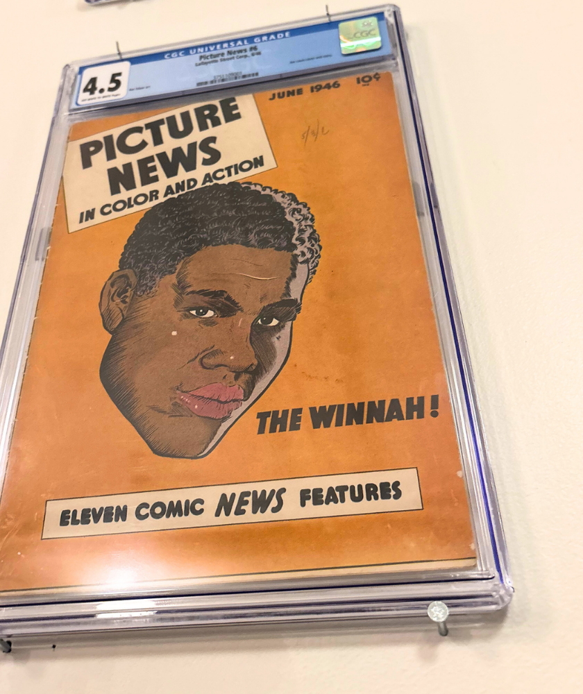 Vintage comic book in protective case displayed on a white wall featuring a man’s face.