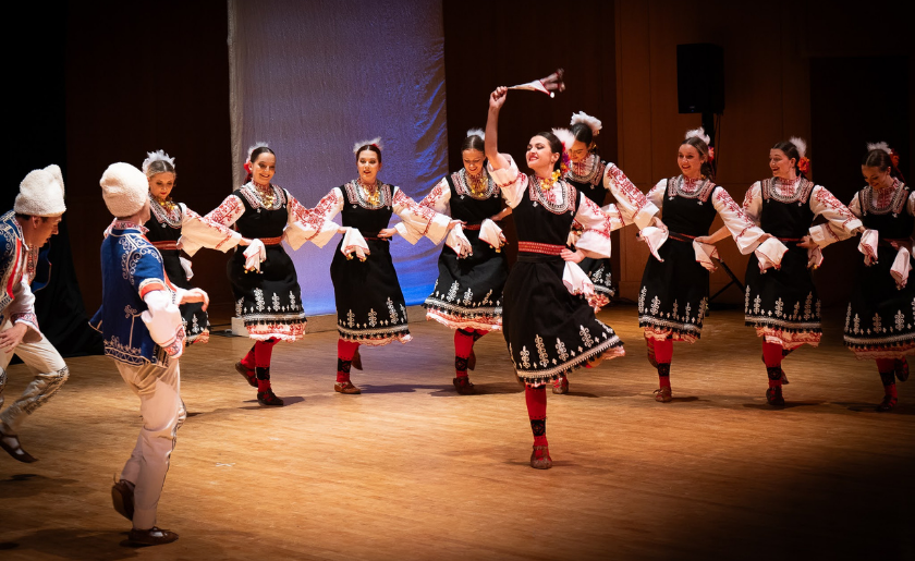 A group of dancers in traditional clothing performing on stage.