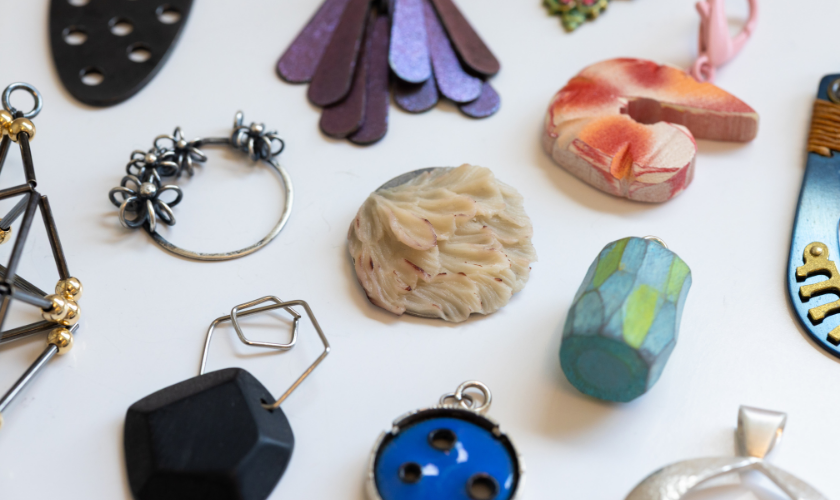 Assorted handmade jewelry pieces and charms displayed on a white surface.