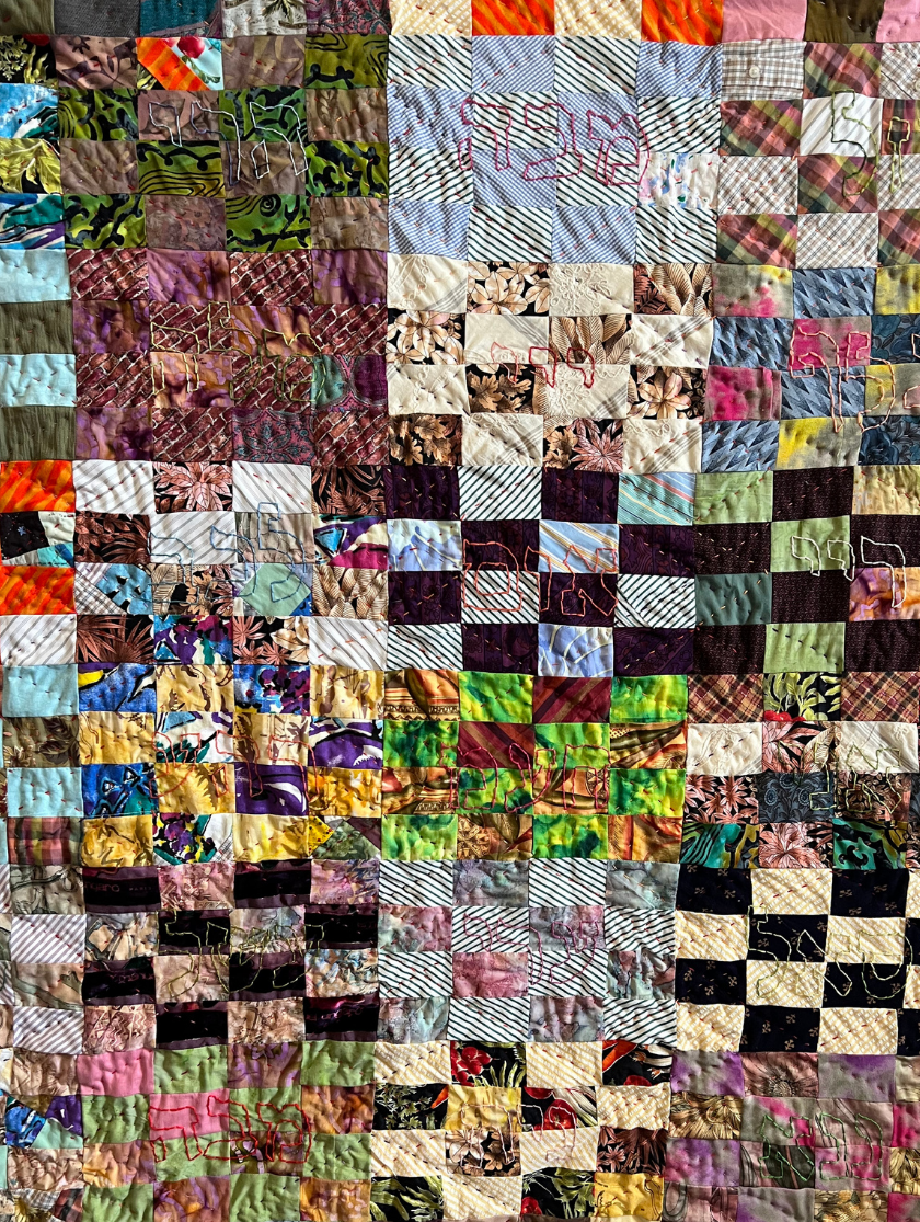 A colorful patchwork quilt made of small, patterned fabric squares sewn together.