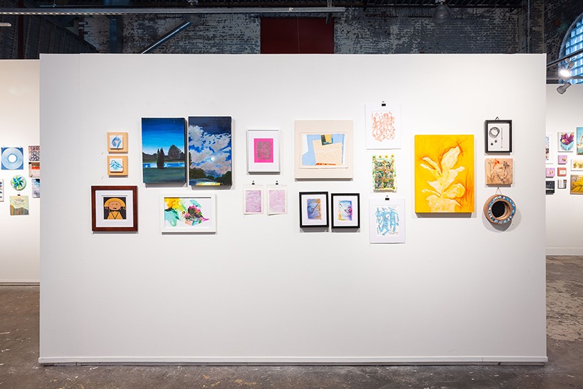 An assortment of colorful artwork of various sizes shown on a white gallery wall