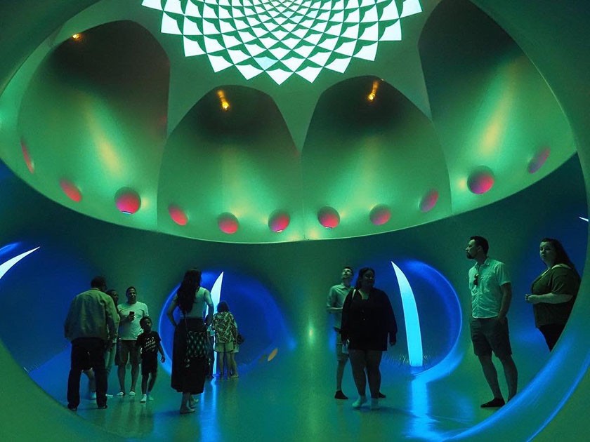 People stand inside a blue-and-green art installation