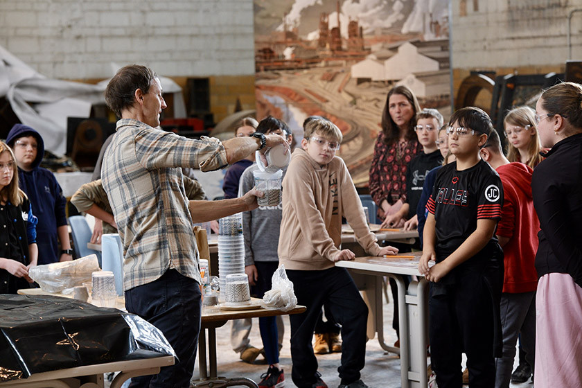 An adult teaches arts to a group of children