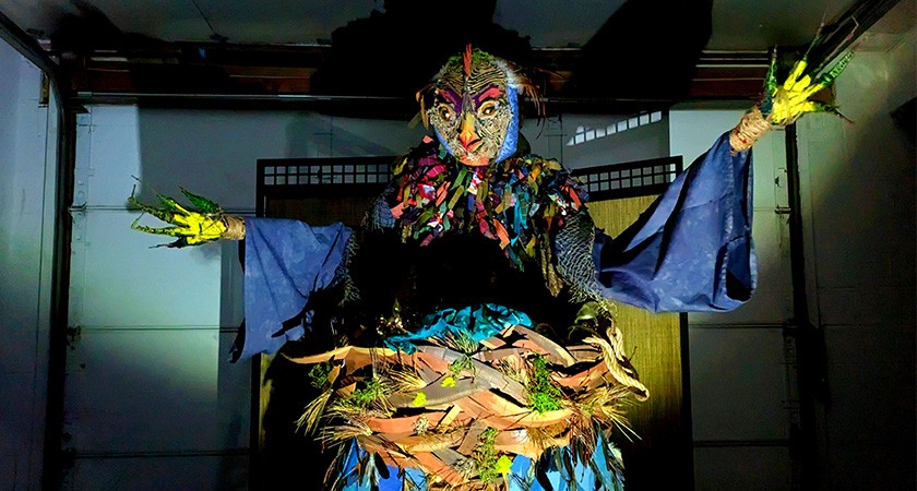 A giant puppet stretches out its arms