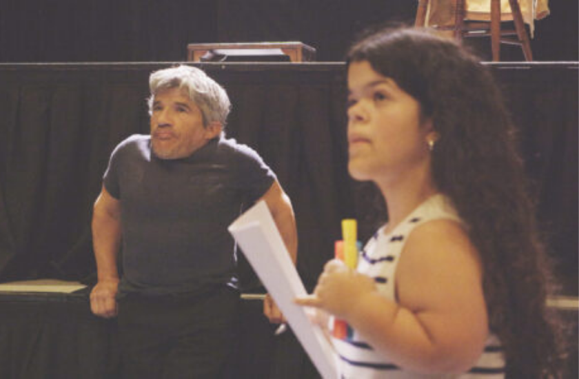 A man and a woman, both little people, perform a scene together on stage