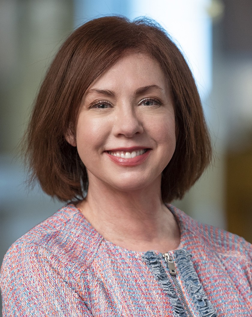 Smiling white woman with shoulder-length straight brown hair