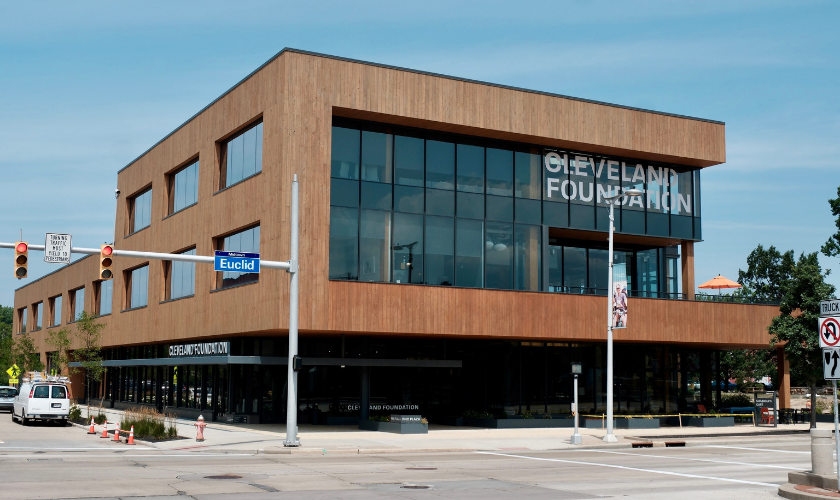 Modern building labeled Cleveland Foundation at a city intersection with traffic lights.