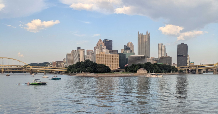 A view of the Downtown Pittsburgh skyline shown from someone on a boat in the river and focused on Point State Park