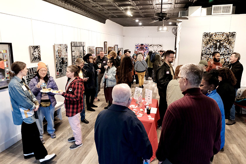 A diverse group of people network inside an arts space