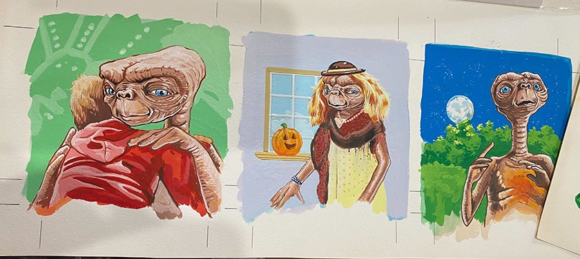 A piece of paper containing three color illustrations of ET, including crop marks