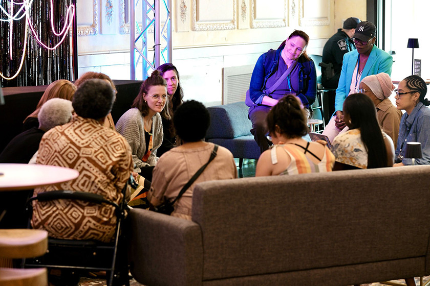 A group of people sit in a circle, engaged in conversation