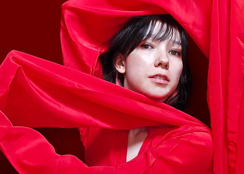 Close up of person framed by bright red fabric