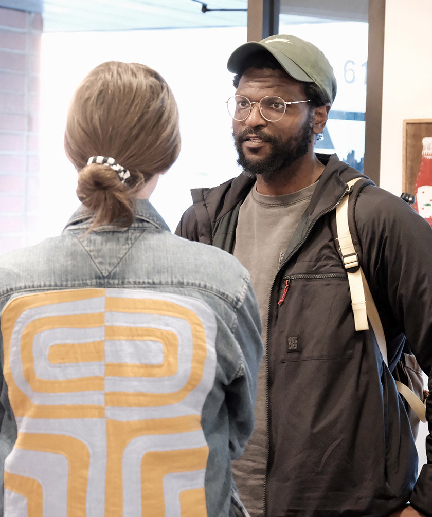 Two people talk inside an arts space