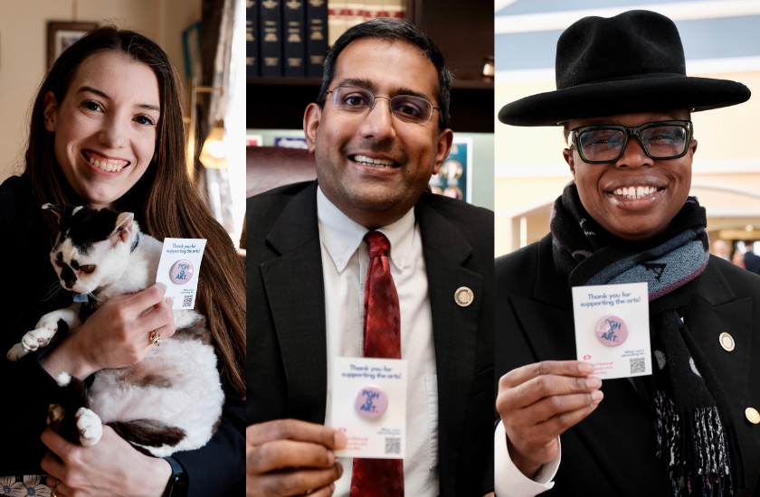 Three smiling people hold Thank you for supporting the arts! cards and pose for the camera. One person is also holding a cat.