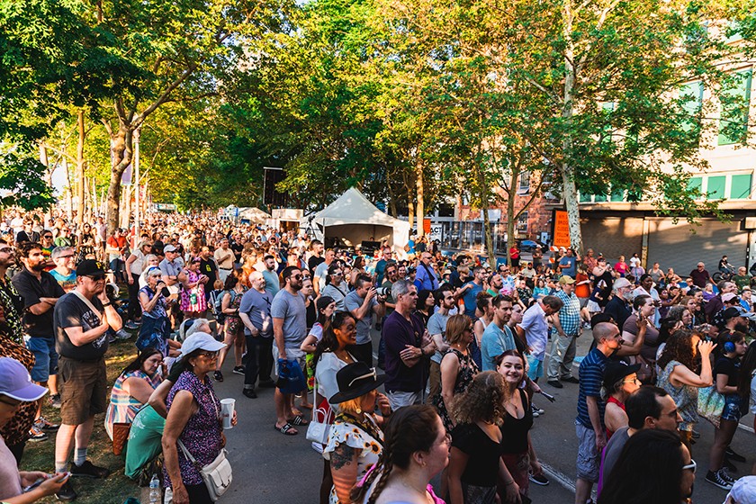 Big crowd of people looking at arts booths during an outdoor festival